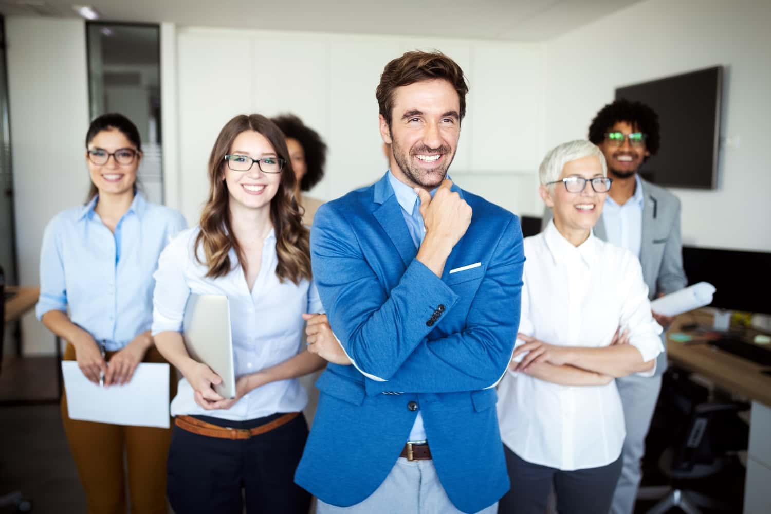 Smiling AdamTech remote agent wearing a headset in a modern, professional workspace